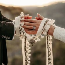 A couple clasping hands during a wedding ceremony.