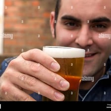 A person lifting a drink in a traditional pub