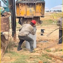 A construction machine driving a foundation pile into the soil.