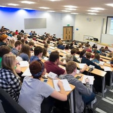 Students seated during a lecture in a university hall.