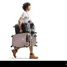 A person straining while carrying a heavy suitcase.