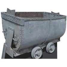 A small rail cart loaded with ore inside a mine.