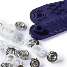 The snap fasteners along the bottom of a baby onesie.