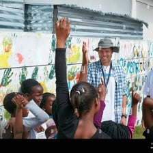 An enthusiastic person raising a hand to volunteer.