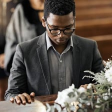 A person grieving quietly at a memorial.