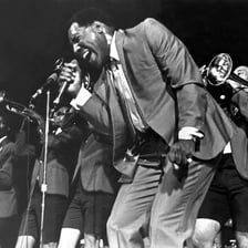 A portrait of soul singer Otis Redding performing.