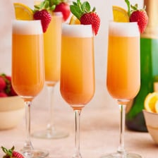 A glass of mimosa made with orange juice and sparkling wine.