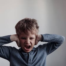 A frustrated person visibly overwhelmed by strong emotion.