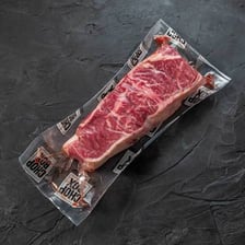 A steak labeled as an end cut on a butcher’s counter.