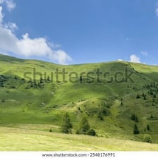 A green, gently sloping valley between hills.