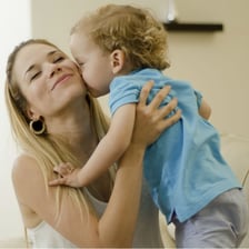 A parent showing affectionate attention to a child