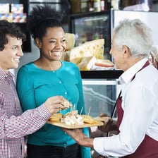A person tasting small food samples at a market