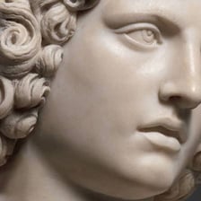 A stone figure conveying a rigid, unyielding appearance.