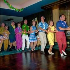 A line of dancers performing the conga at a carnival celebration.