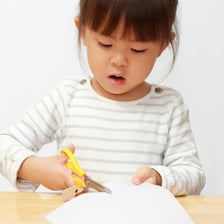 Scissors make a short cut through a piece of paper.