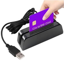 A payment card being swiped through a card reader.