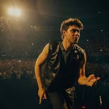 Niall Horan performing onstage with a microphone