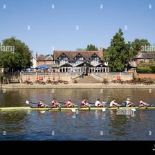 A boathouse beside a river with rowing shells.