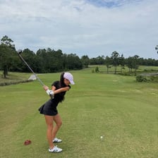 A golfer swinging a club on a golf course.