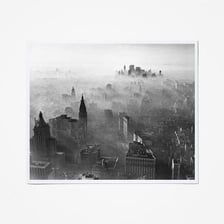 A city skyline partly obscured by a layer of gray smog.