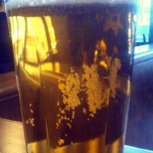 A cloudy wheat beer in a glass, with yeast contributing to its appearance