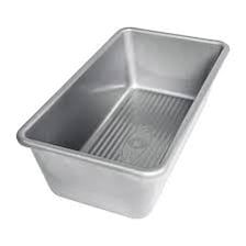 A rectangular metal loaf pan holding a baked loaf.