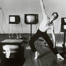 A choreographer observing dancers practicing coordinated movements