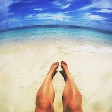 A person tanning on a sunny beach.