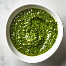 A bowl of green basil pesto