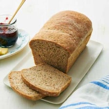 A rye bread loaf beside a glass of rye whiskey