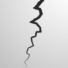 A prominent crack forming a rift in a wall.