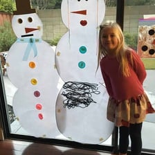 A group of people building a very large snowman.