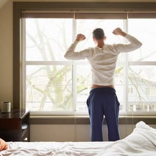 A person getting out of bed in the morning