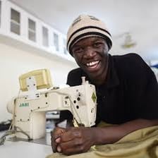 A person sewing fabric with a needle and thread.