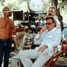 Clothed actors rehearse a scene on a film set.