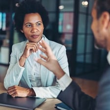 A manager speaking to a colleague during a serious workplace discussion.