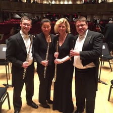 Flutists seated together in an orchestra.