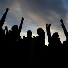 A group of people raising their hands during a protest.