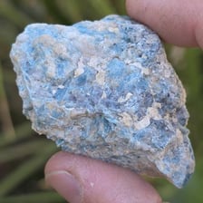 A rough rock specimen containing visible mineral deposits.