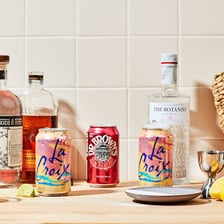 Several sodas beside liquor bottles for mixing drinks