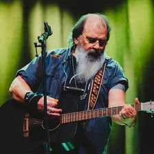 Steve Earle performing with a guitar.