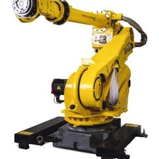 An industrial robot operating beside a factory assembly line.