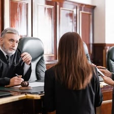 A judge seated at the bench in a courtroom.