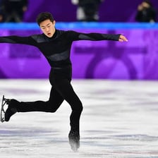A figure skater airborne during a quadruple jump