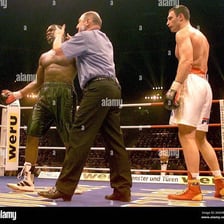 A boxing referee signaling that a fight has been stopped.