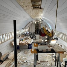 An airplane interior imaginatively arranged as a livable space.