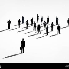 A reserved person standing slightly apart from a social group