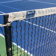 A tennis net stretched across a tennis court.