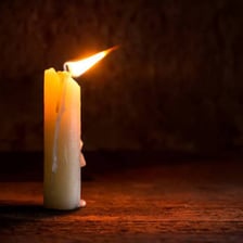 A gust of wind extinguishing a candle flame