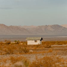 A small house visible far across an open landscape